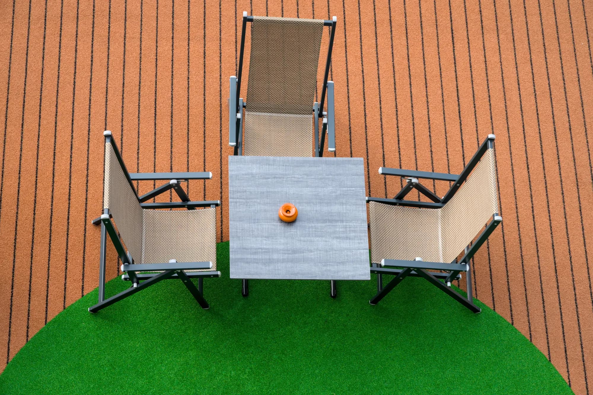 Round artificial grass rug under a table and chairs