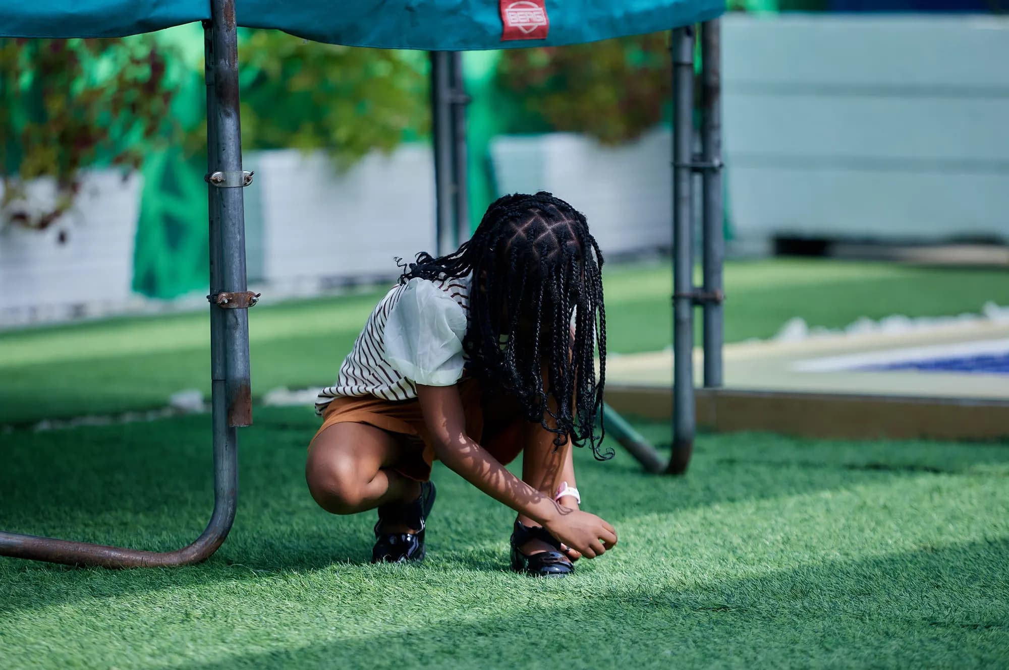 Child playing on artificial grass in a back yard