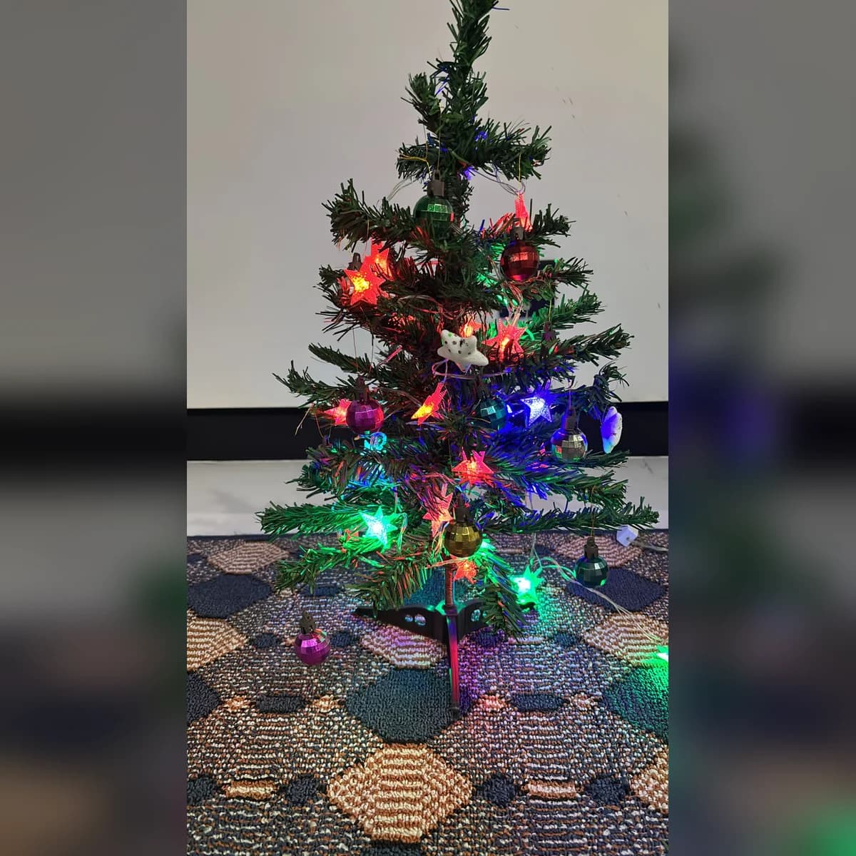 2 ft green artificial Christmas tree, set up at a customer's home