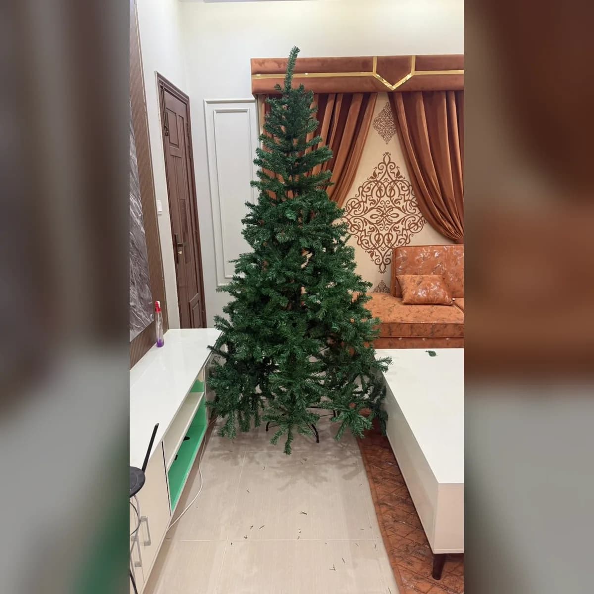 7 ft green artificial Christmas tree, set up at a customer's home