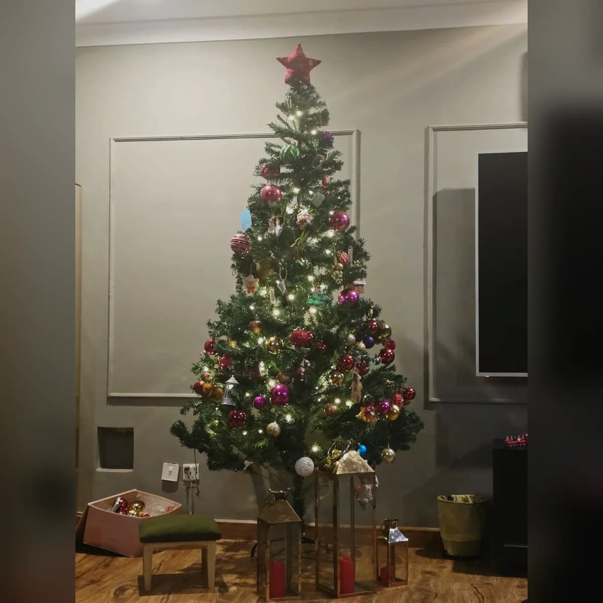 8 ft green artificial Christmas tree, set up at a customer's home
