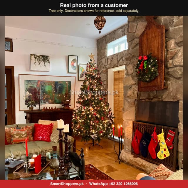 9 ft green Christmas tree with lights in a living room with a stone fireplace