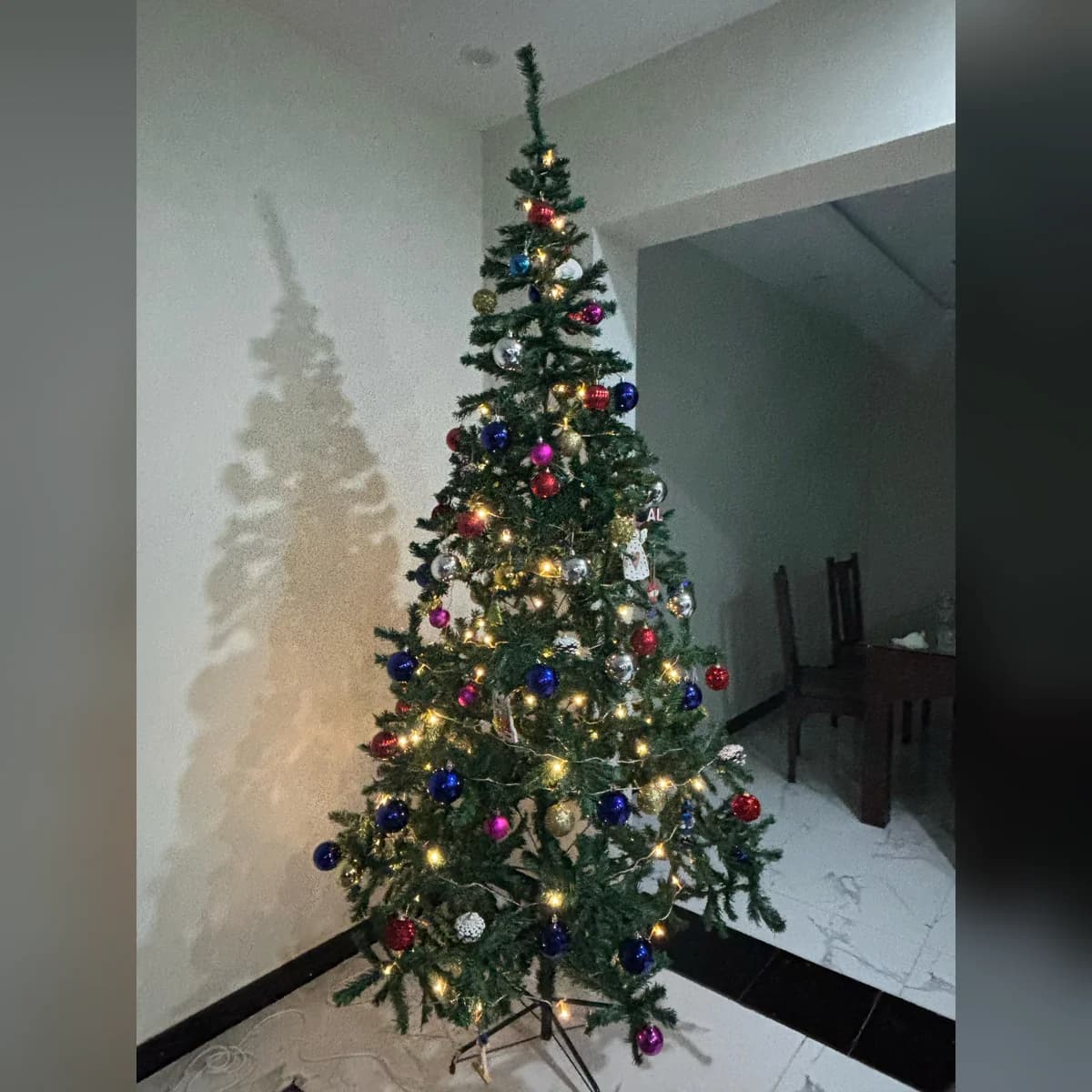 9 ft green artificial Christmas tree, set up at a customer's home