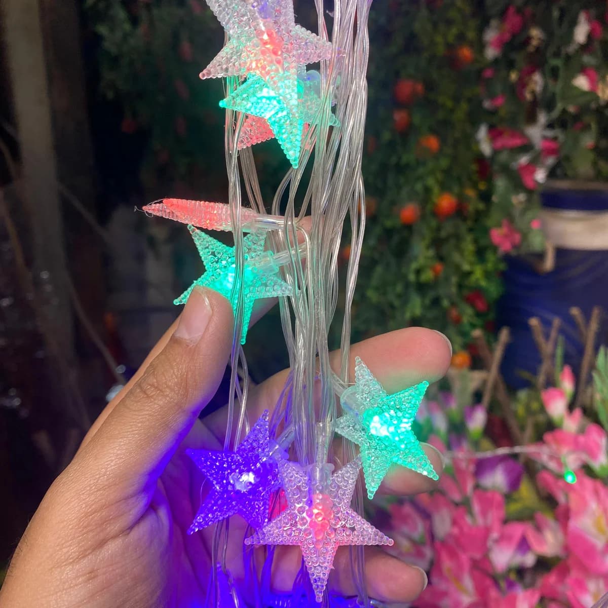 Star string lights glowing pink, green, blue and purple, for Christmas decoration