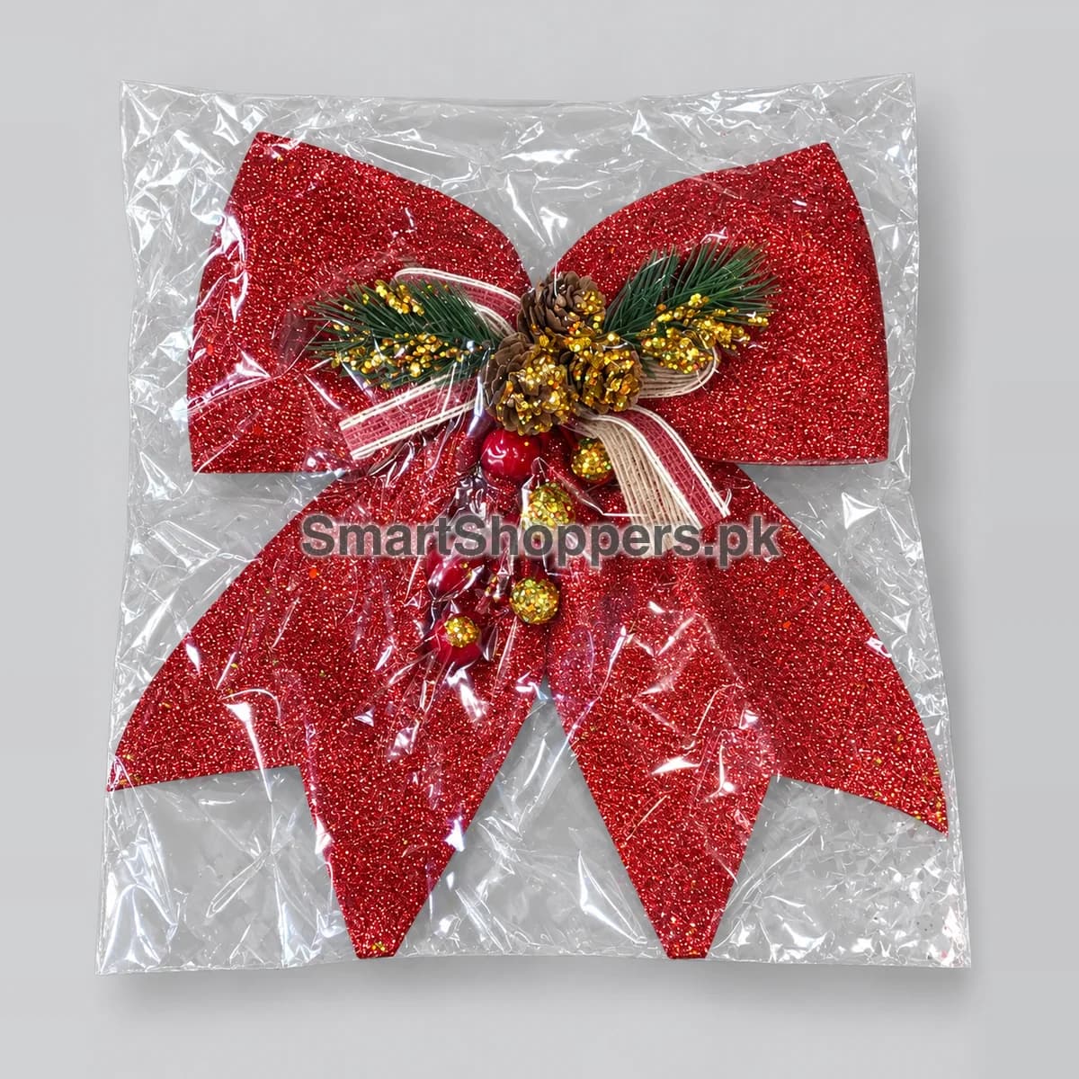 Large red glitter bow with holly and gold accents, in its pack