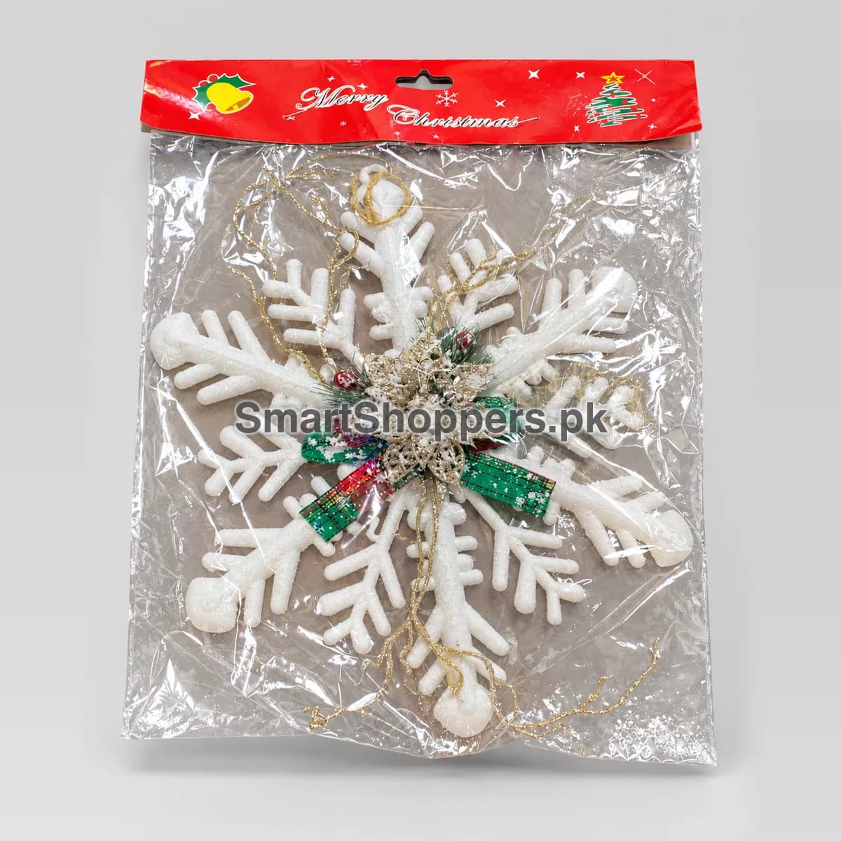Large white snowflake ornament with red berries and greenery in its pack